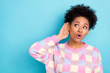Photo of impressed brunette young lady look empty space wear pink sweater isolated on blue color...
