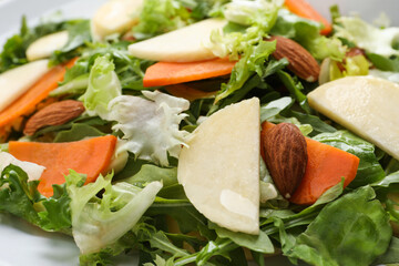 Delicious turnip salad with vegetables and almonds on plate, closeup