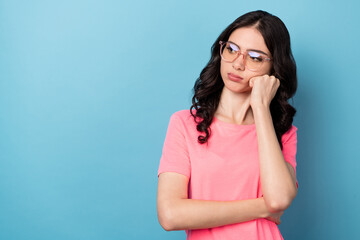 Photo of young lovely woman hand touch cheek minded look empty space boring isolated over blue color background