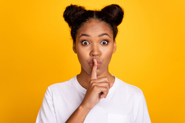 Photo of young pretty african woman finger covr lips shh keep secret confidential isolated over yellow color background