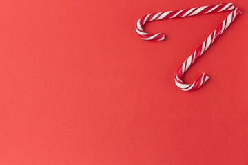 two red candy canes on red background