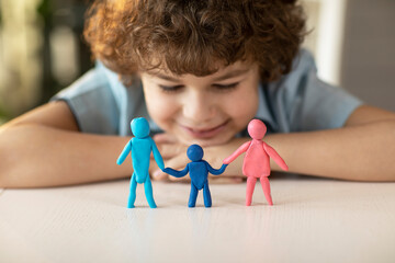 The boy made figures of people from plasticine dad, mother and child, ,family relations concept