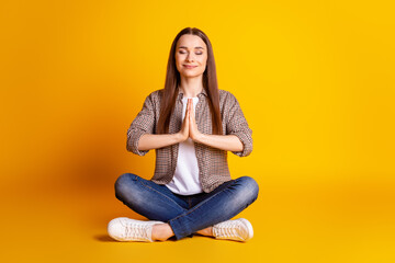 Full body photo of young lovely girl sit lotus pose meditate sak pray wwish dreamy luck isolated over yellow color background