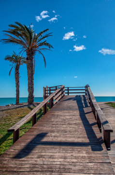 Amanecer en Moncófar, Castellón , Valencia. Una mar calmada un mirador de madera y un horizonte azul.