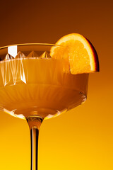 Glass of vegan fruit alcohol free mimosa cocktail close-up. Refreshing festive orange mocktail
