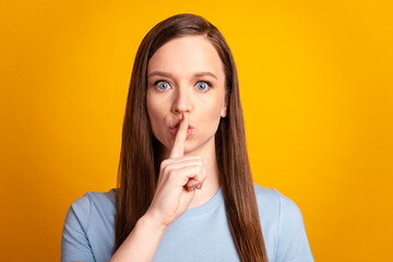 Photo of young charming woman cover lips finger shh keep secret confidential isolated over yellow...