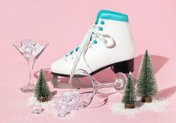 New Year creative layout with skate, martini cocktail glasses ,christmas trees, ice cubes and snow on pastel pink background. Winter idea. 80s or 90s retro aesthetic party celebration concept.