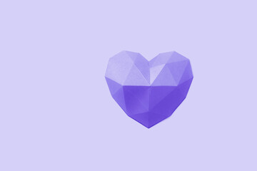 Polygonal paper heart shape on color of the year 2022 Very Peri. Holiday background copy space for Valentines Day. Concept Plain colored minimal style.