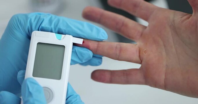 Doctor in rubber gloves measuring patient blood glucose using glucometer closeup 4k movie slow motion
