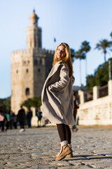 Teenager girl sightseeing next to the Torre del Oro in Seville in Winter.