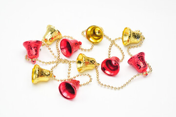 Christmas bells of red and gold color with a chain on a white background