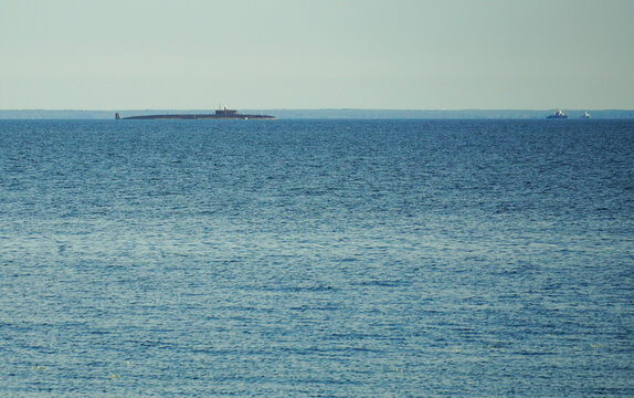 Russian military submarine on the horizon of the bay or sea. Summer and blue water and sky. High quality photo