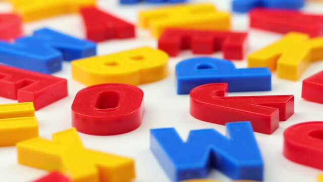 Colorful letters rotate on a white background.