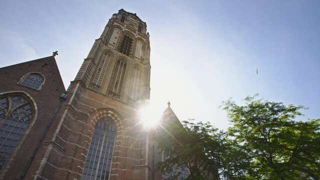 Rotterdam, Netherlands - June 01 2020: Timelapse of the rising sun behind the Laurenskerk at the city center.