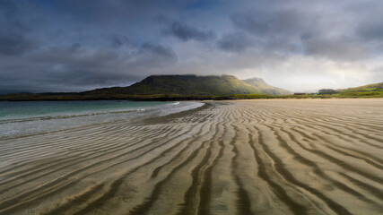 Low tide sandy beach on the lovely Ireland coast, with dramatic clouds and sunset light.