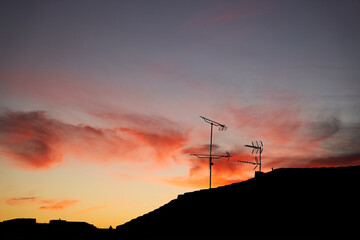 silhouette of television antennas at sunset