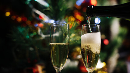 Christmas and New Year celebration with champagne. New Year holiday decorated tree, Two Champagne Glasses