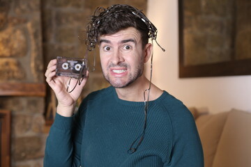 Man holding broken cassette tape