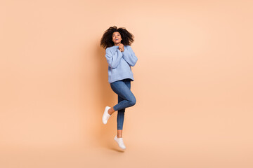 Fototapeta na wymiar Full length body size view of attractive cheerful amazed delighted girl jumping hope pray isolated over beige pastel color background