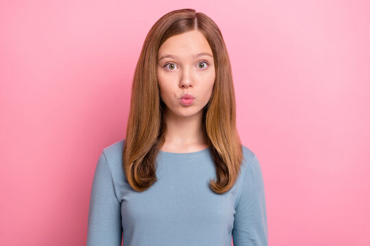 Portrait of attractive funny brown-haired girl sending air kiss feelings isolated over pink pastel color background