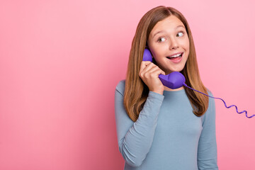 Naklejka premium Portrait of attractive cheerful funny girl talking on phone copy blank space isolated over pink pastel color background
