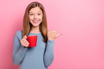 Portrait of attractive trendy cheerful funny girl drinking coffee showing copy space isolated over pink pastel color background