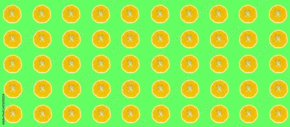 Poster lemon slices pattern, top view of lemon slices isolated on a green background.