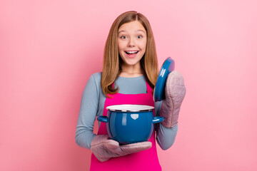 Portrait of attractive cheerful funny amazed girl cooking domestic cuisine soup isolated over pink...