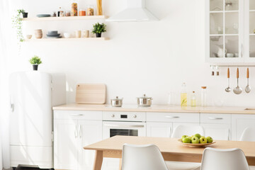 New scandinavian design after renovation. White and wooden furniture with different utensils, kitchenware supplies