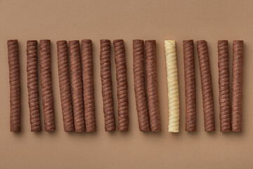 Stand out from the crowd concept. Chocolate wafer rolls stacked in a row. Individuality. Top view