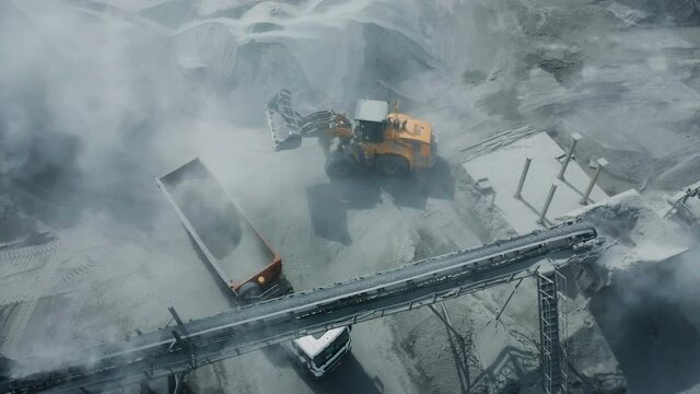 Granite mining by open-pit method. The video shows loading. The loader loads the mass into a dump truck.