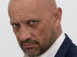 Portrait of a bald, brutal man with a beard. Not a shaved European man. Successful businessman in a...