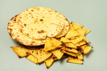 Stack of Tasty Homemade Whole Wheat Flour Tortilla and Tortilla Chips on a Green Background Top View Copy Horizontal