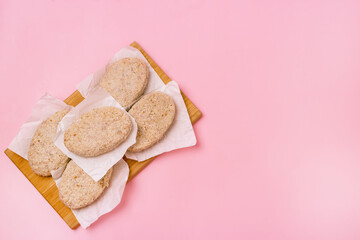 Raw Frozen Minced Meat Balls or Cutlets on Pink Background Selective Focus Homemade Cutlets for Cooking Top view Copy Space