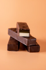 Stack of Tasty Chocolate Sweets Candy on Yellow Background Vertical