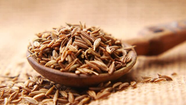 cumin seeds on spoon on table , close up 