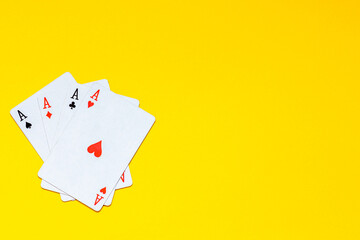 A fan of playing cards consisting of four Ace Isolated on yellow