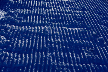 Close-up of pattern in the snow after reparation of slope by snowcat at mountain village Stoos, Canton Schwyz, on a sunny winter day. Photo taken December 20th, 2021, Stoos, Switzerland.