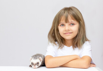 Cute little girl holding a ferret pet . Isolated on pbackground.