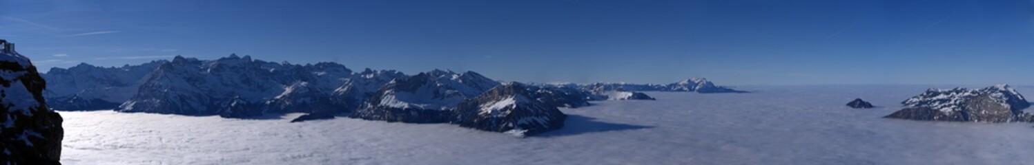 Panoramic mountain view seen from mountain Fronalpstock, Canton Schwyz, on a beautiful winter day with sea of fog. Photo taken December 20th, 2021, Stoos, Switzerland. 