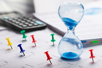 Best time for investment. Hourglass, financial charts, calculator and calendar with pins.