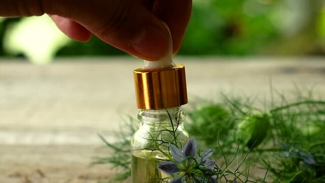 Black cumin oil in a bottle. Selective focus.