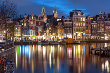 Evening Amsterdam canal Amstel with typical dutch houses at night, Holland, Netherlands.