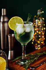 Fresh Mojito cocktail with lemon, rosemary and ice in jar glass on dark blue background. Summer cocktail