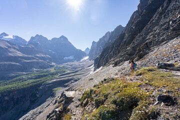 Female hiker moving through beautiful mountain pass with blue skies, Canada 