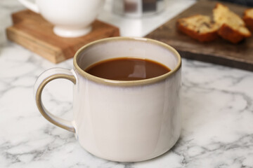 Cup of fresh aromatic coffee on white marble table