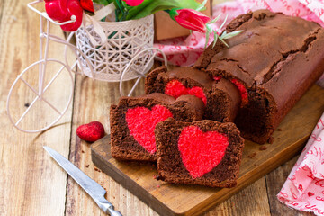 St. Valentine's Day, Birthday or Mother's Day dessert, homemade festive food. Homemade sweet chocolate brownie cake with red heart on a wooden rustic tabletop.