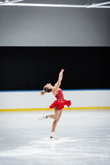 full length of happy figure skater with raised hands doing layback in professional ice arena © LIGHTFIELD STUDIOS