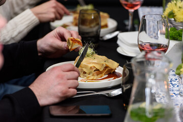Man eating Francesinha, traditional Portuguese sandwich in a restaurant. National cuisine concept