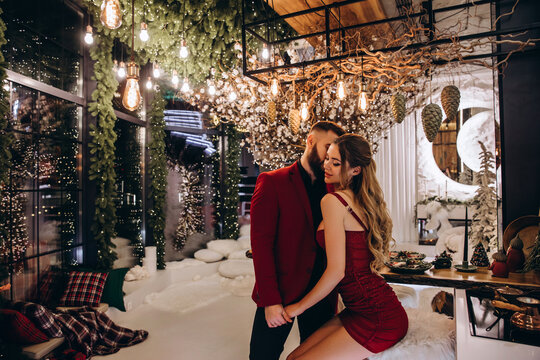 The guy and the girl are celebrating Christmas. A loving young married couple on New Year's Eve. Love story. Location in the kitchen.